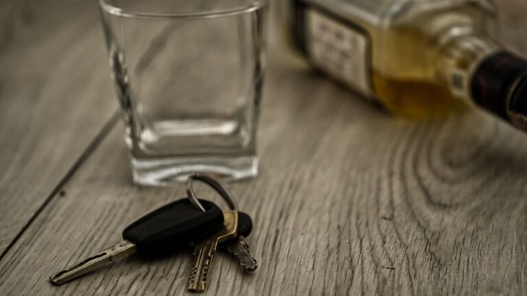 Car keys next to a glass of alcohol