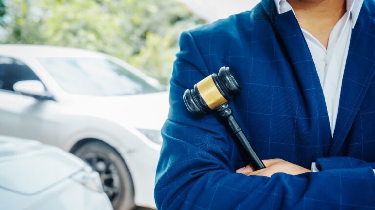 lawyer is standing in front of a car with judge's gavel