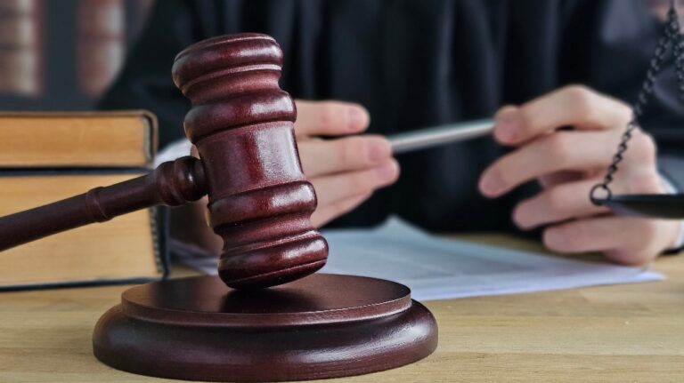 judge is holding pen near law books and judge's gavel