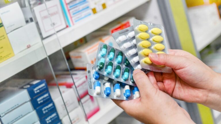 Hand holding medicine capsule pack at the pharmacy drugstore