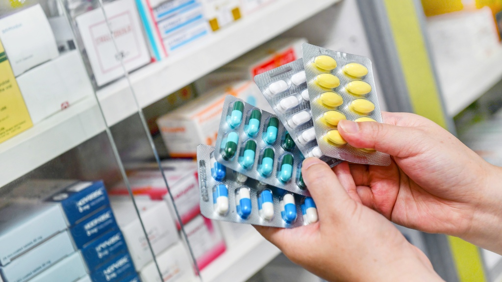 Hand holding medicine capsule pack at the pharmacy drugstore